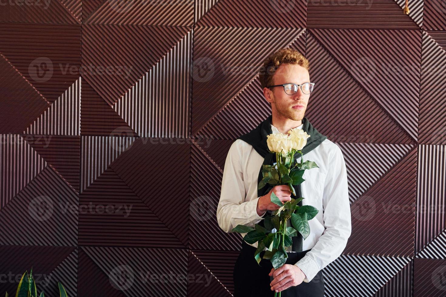 uomo detiene fiori. in casa di nuovo moderno lusso ristorante foto