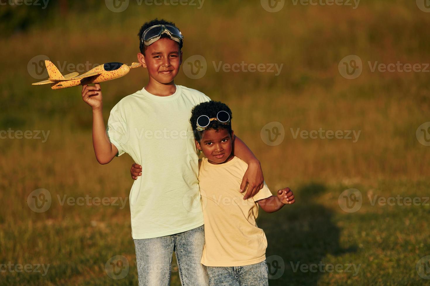 a estate giorno insieme. Due africano americano bambini avere divertimento nel il campo foto