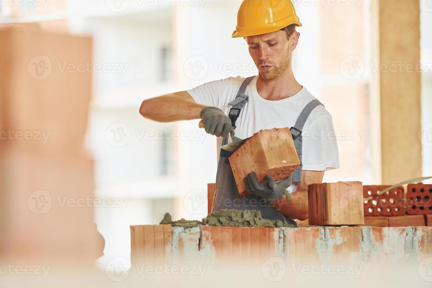 edificio processi. giovane uomo Lavorando nel uniforme a costruzione a giorno foto