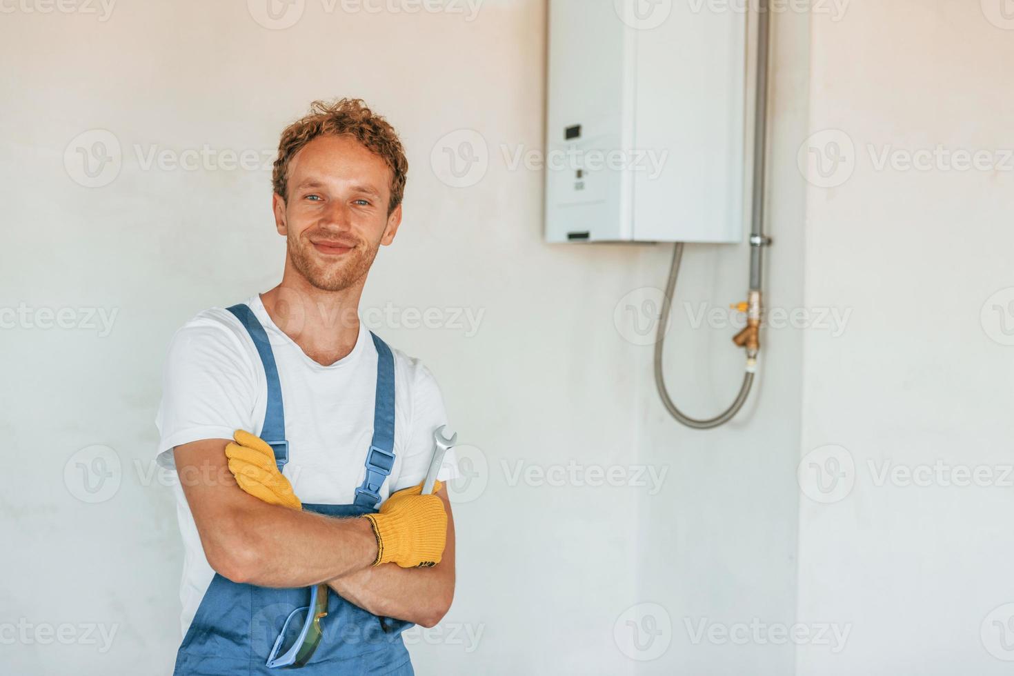 riparazione acqua stufa. giovane uomo Lavorando nel uniforme a costruzione a giorno foto