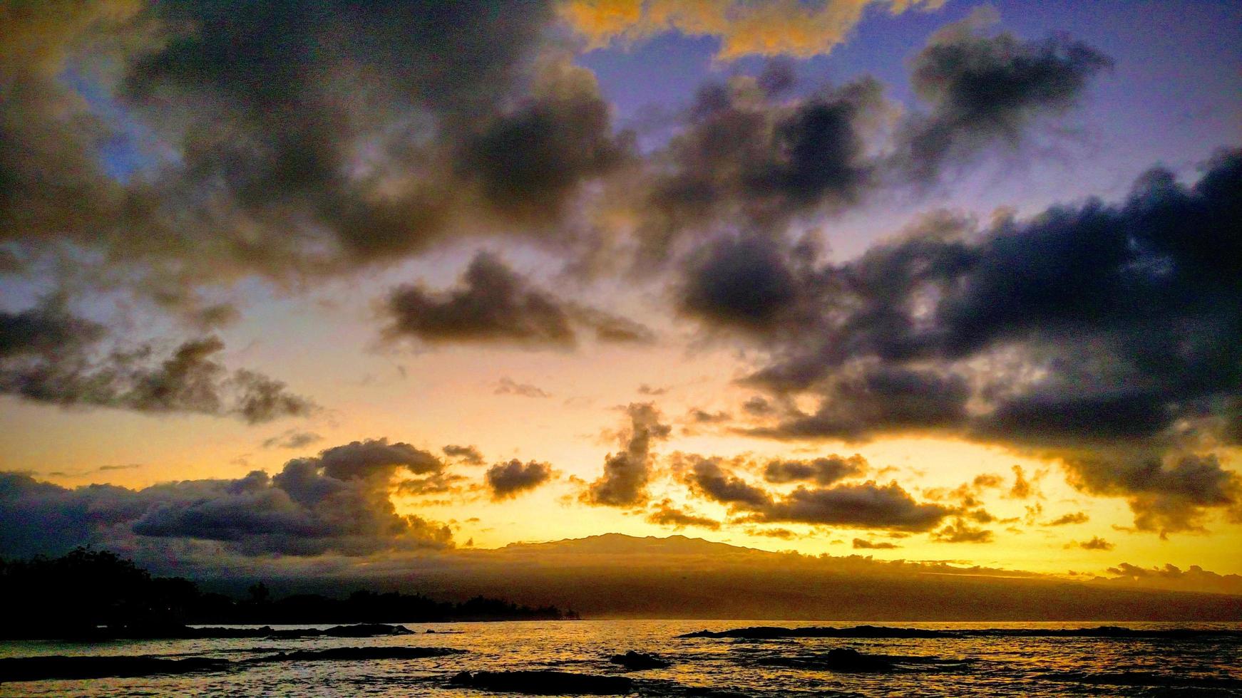 specchio d'acqua sotto il cielo nuvoloso durante il tramonto foto