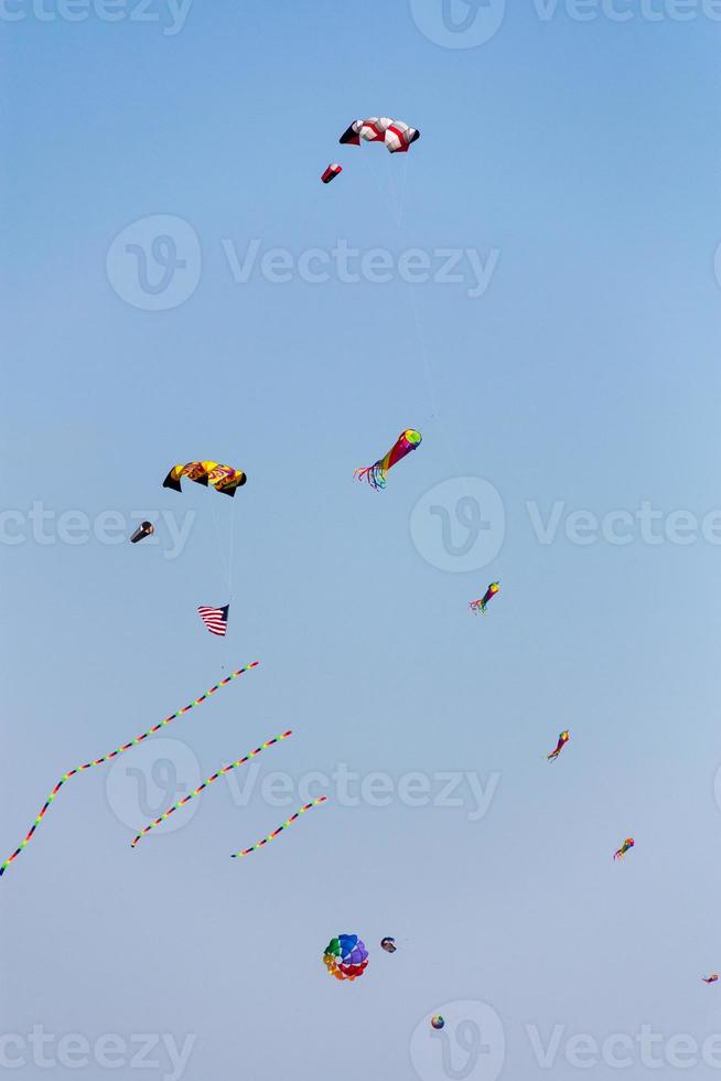 colorato aquiloni volante nel il cielo contro un' blu cielo foto