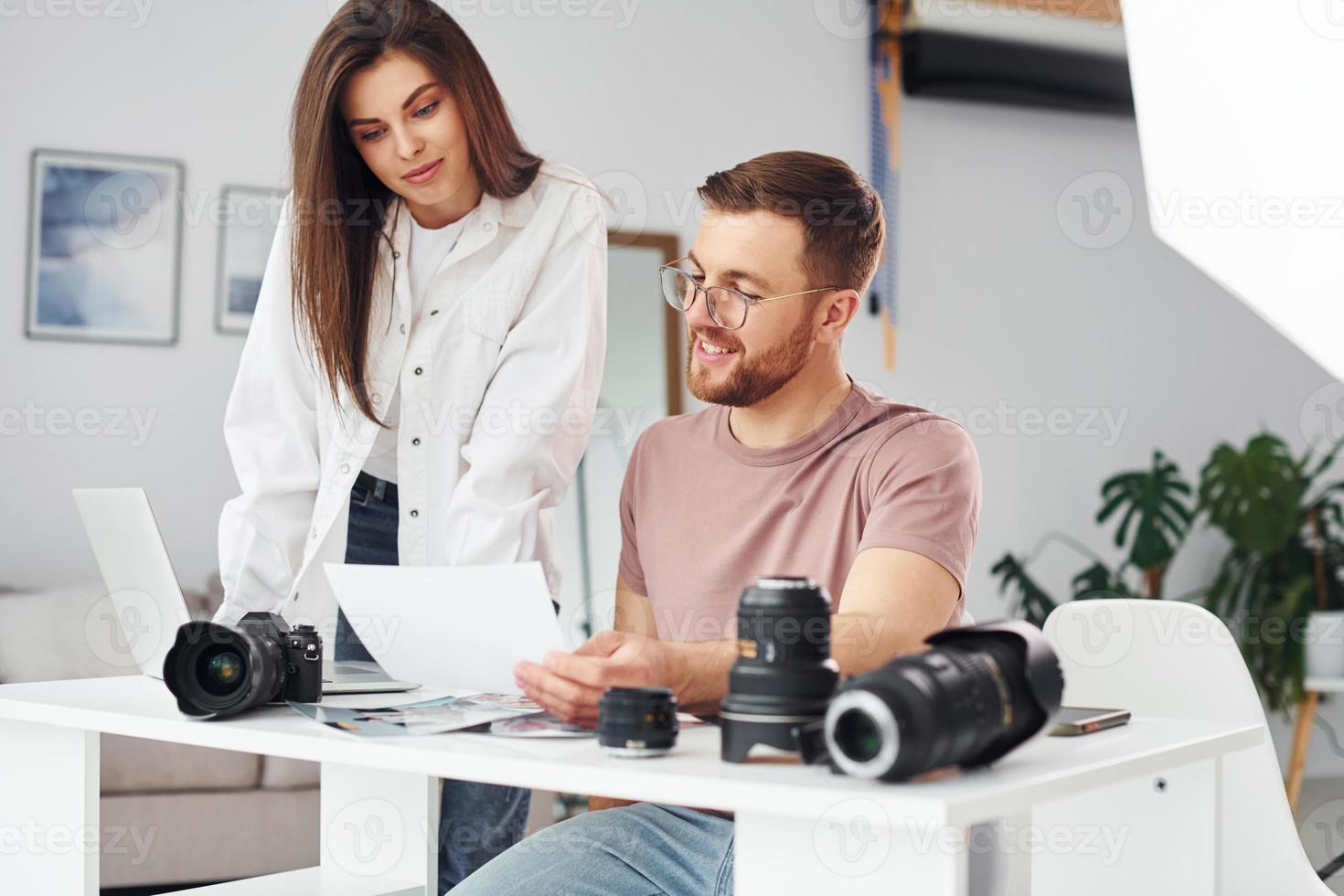 Due fotografi nel casuale Abiti è Lavorando in casa a giorno foto