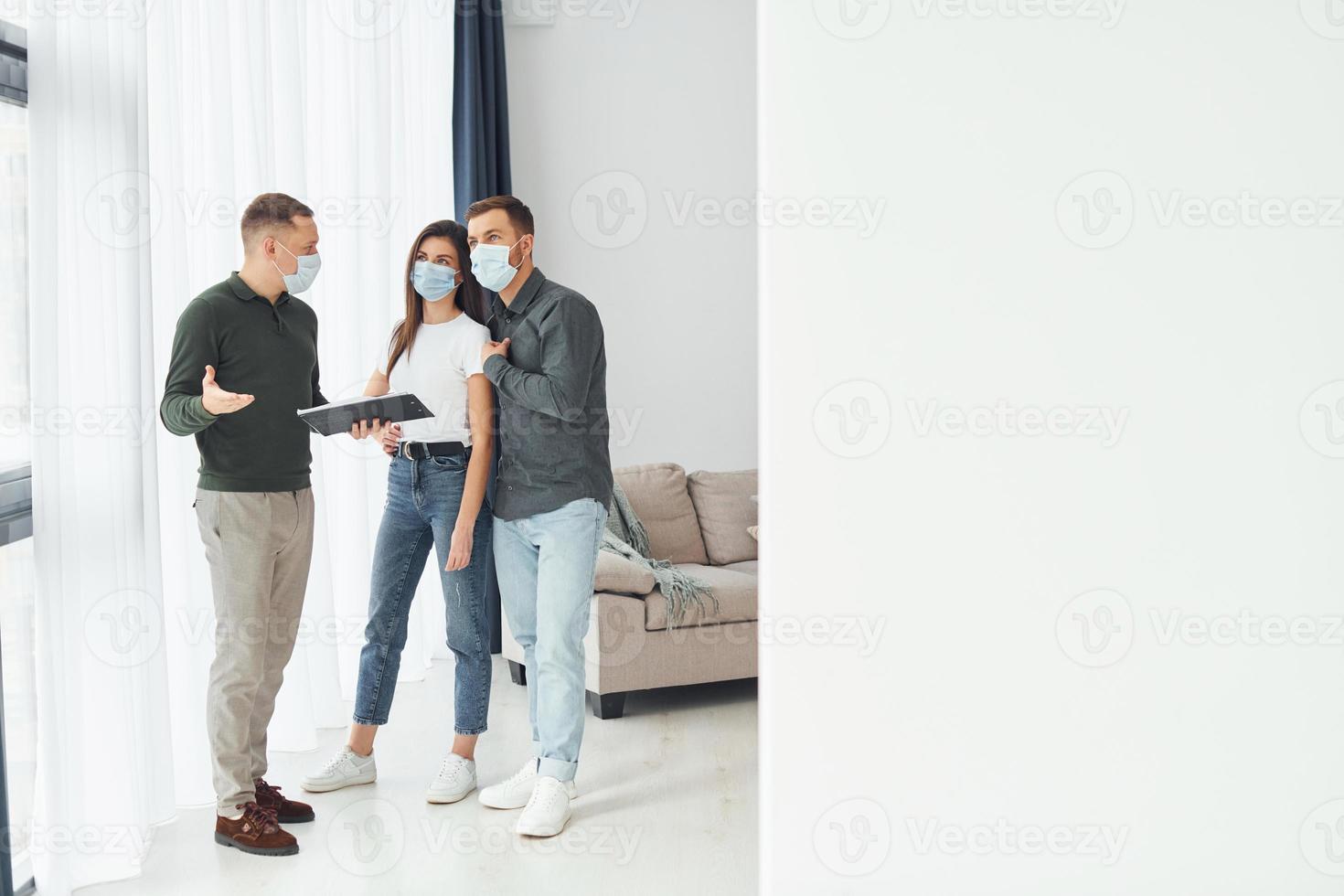 uomo aiuta il giovane coppia nel la scelta un appartamento foto