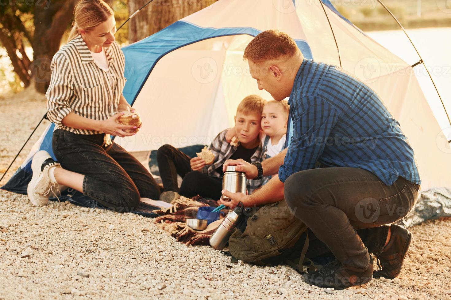 attivo tempo spesa. famiglia di madre, padre e bambini è su il campeggio foto