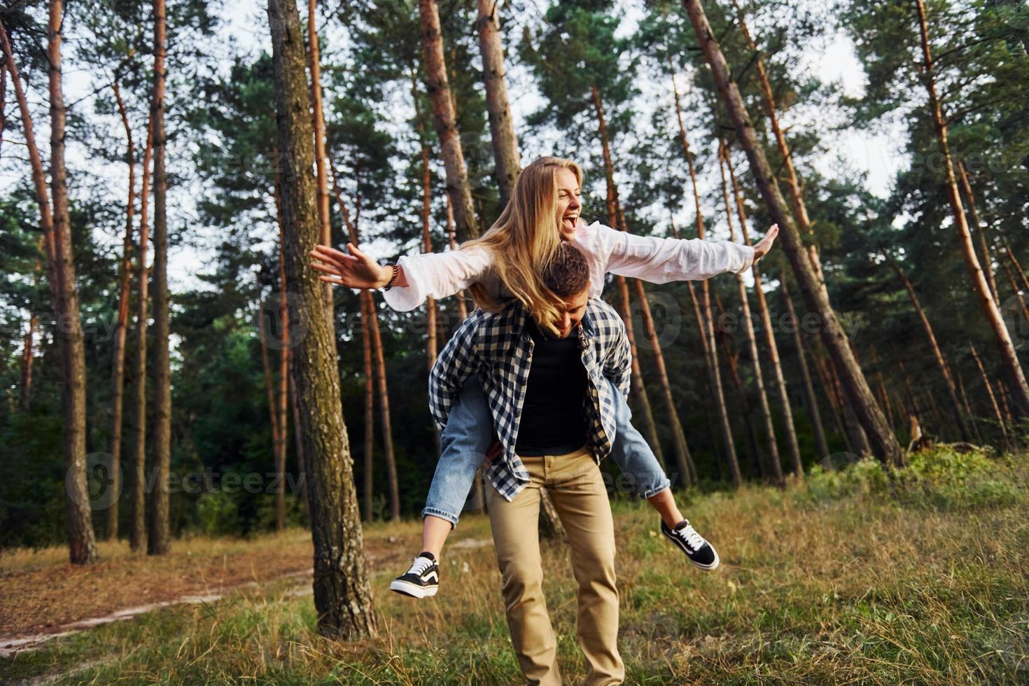 donna è equitazione sua uomo. contento coppia è all'aperto nel il foresta a giorno foto