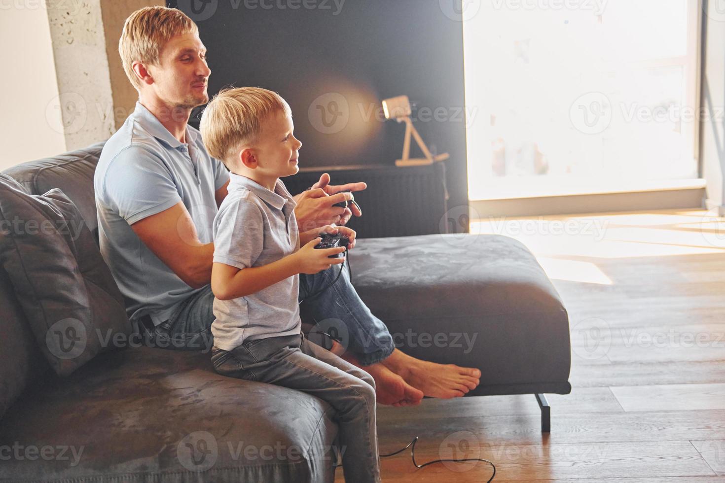 giocando video gioco. padre e figlio è in casa a casa insieme foto