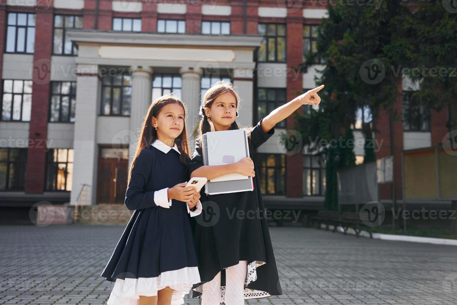 Tenere libri. Due studentesse è al di fuori insieme vicino scuola edificio foto