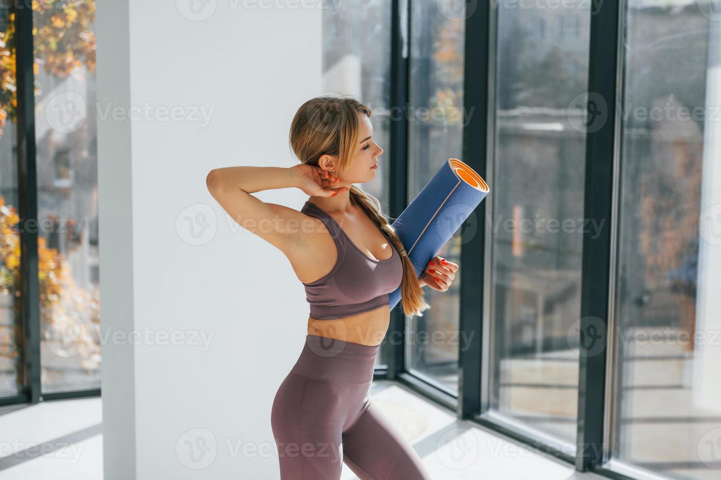 con fitness stuoia. donna nel allegro Abiti fare yoga in casa foto