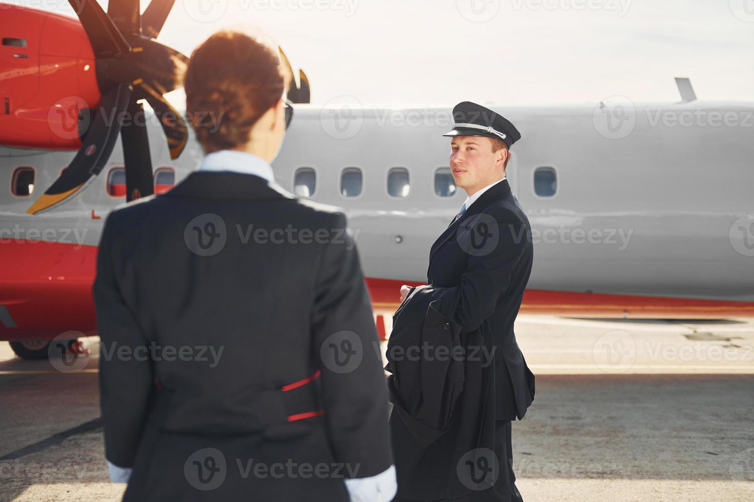 pilota e hostess. equipaggio di aeroporto e aereo lavoratori nel formale Abiti in piedi all'aperto insieme foto