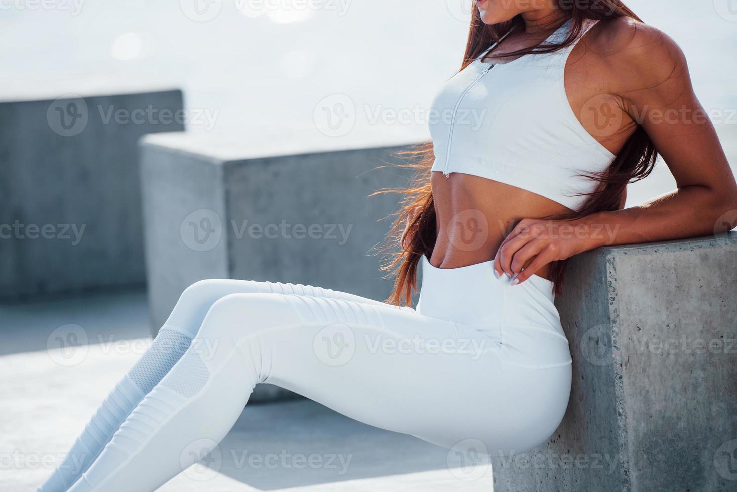 simpatico corpo. fitness donna avendo un' riposo vicino il lago a giorno. bellissimo luce del sole foto