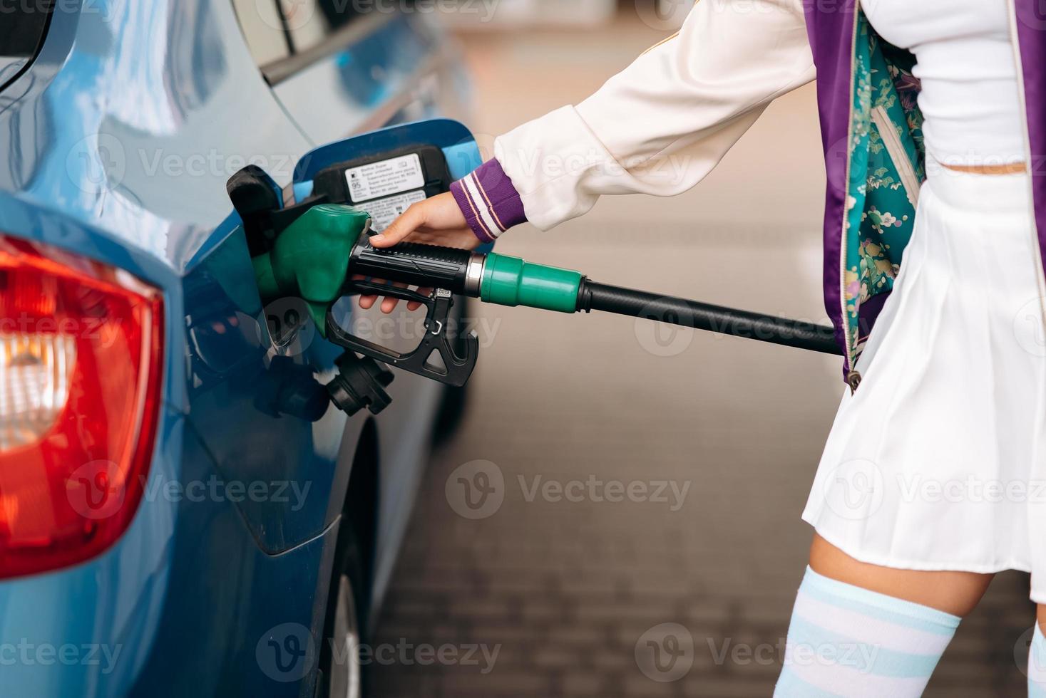 donna Riempimento sua auto con carburante a un' gas stazione foto