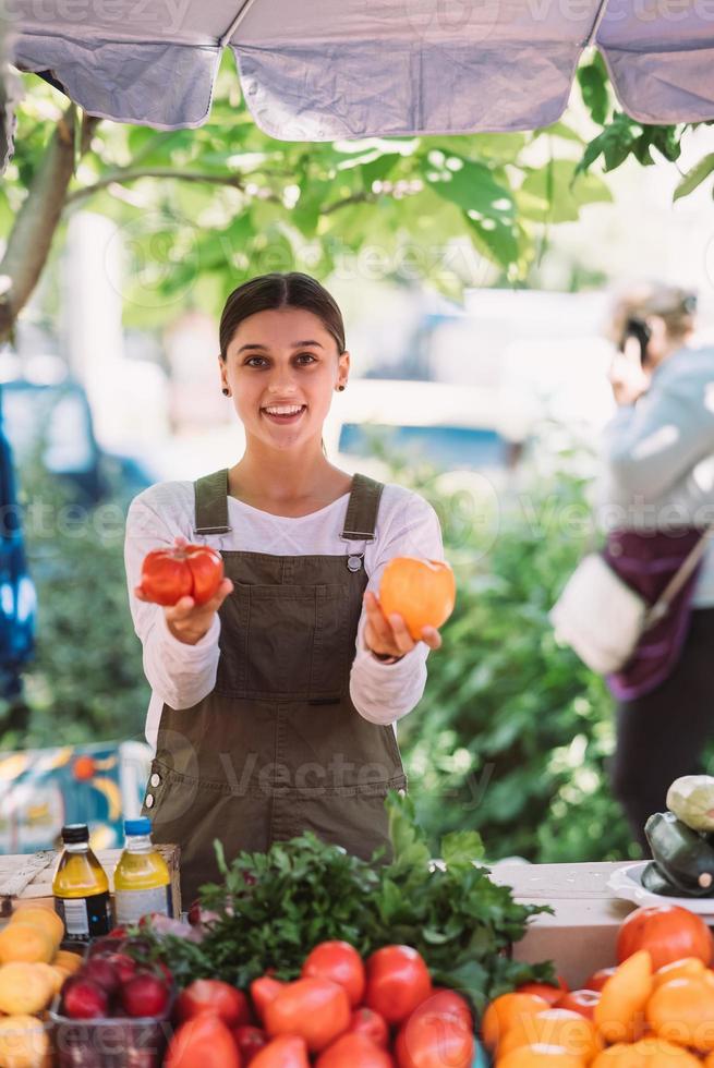 giovane commessa Tenere coltivato in casa pomodori nel mani foto