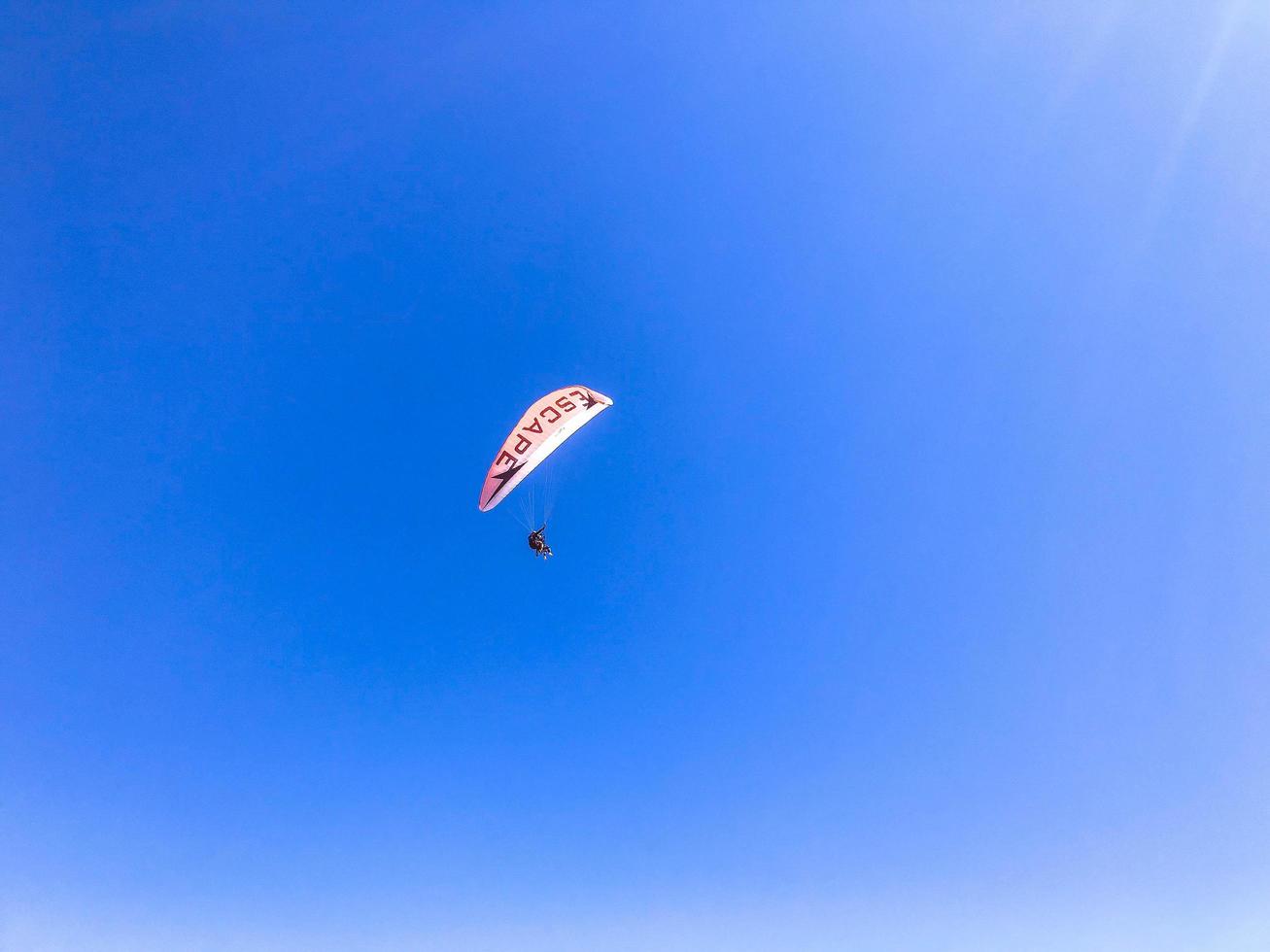 parapendio nel un' caldo nazione. paracadutismo a partire dal il montagna, attivo ricreazione. un' uomo nel un' protettivo completo da uomo mosche nel un' Palloncino foto