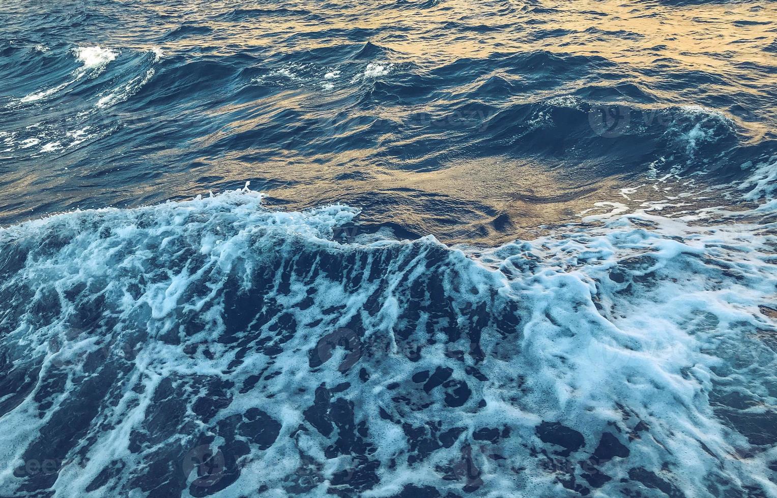 blu acqua con bianca schiuma. bellezza di mare viaggio. riposo di il acqua nel un' caldo nazione. sfondo, struttura. naturale naturale sfondo foto