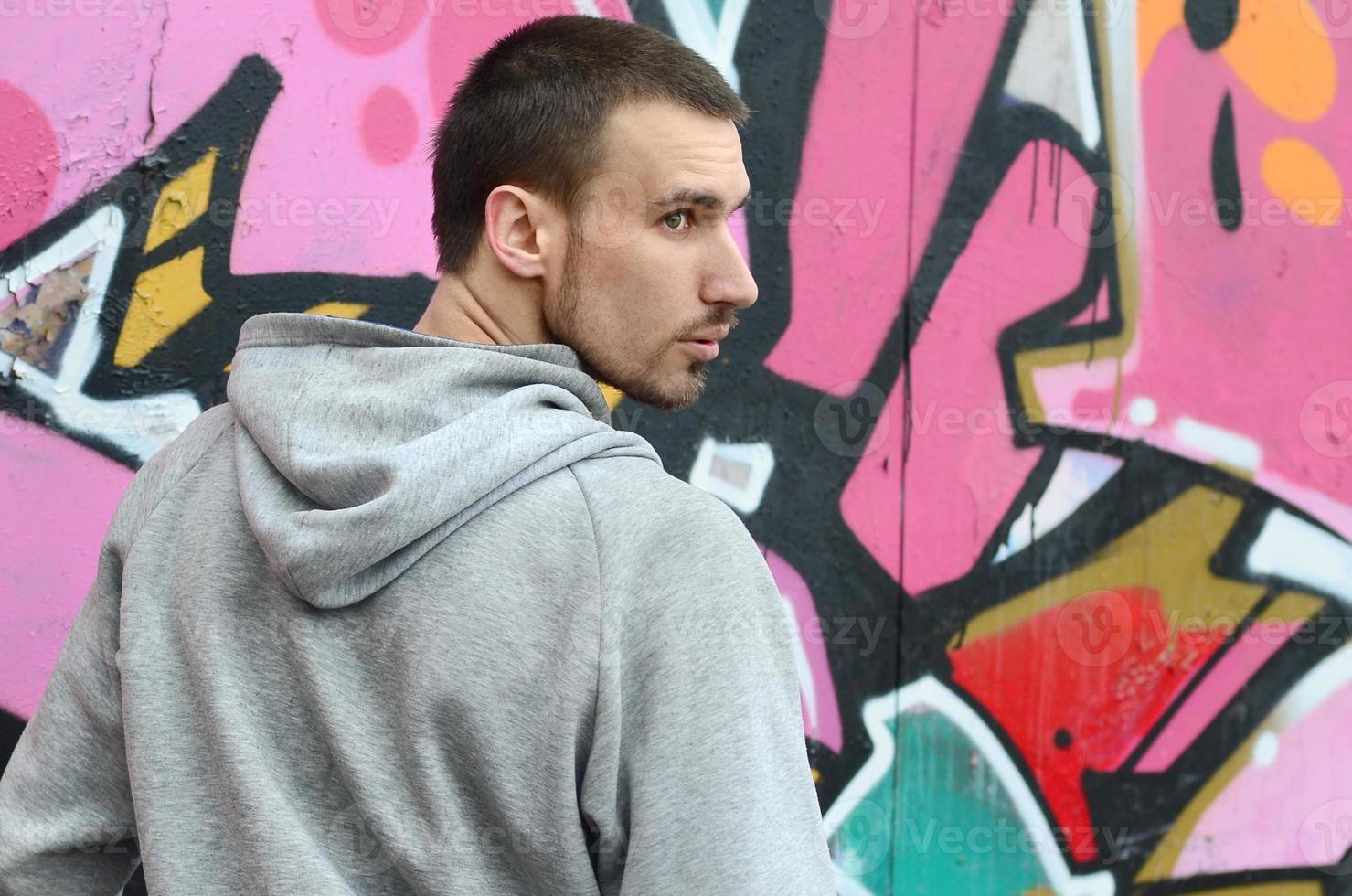 un' giovane graffiti artista sembra in giro mentre disegno. vandalo cerca foto