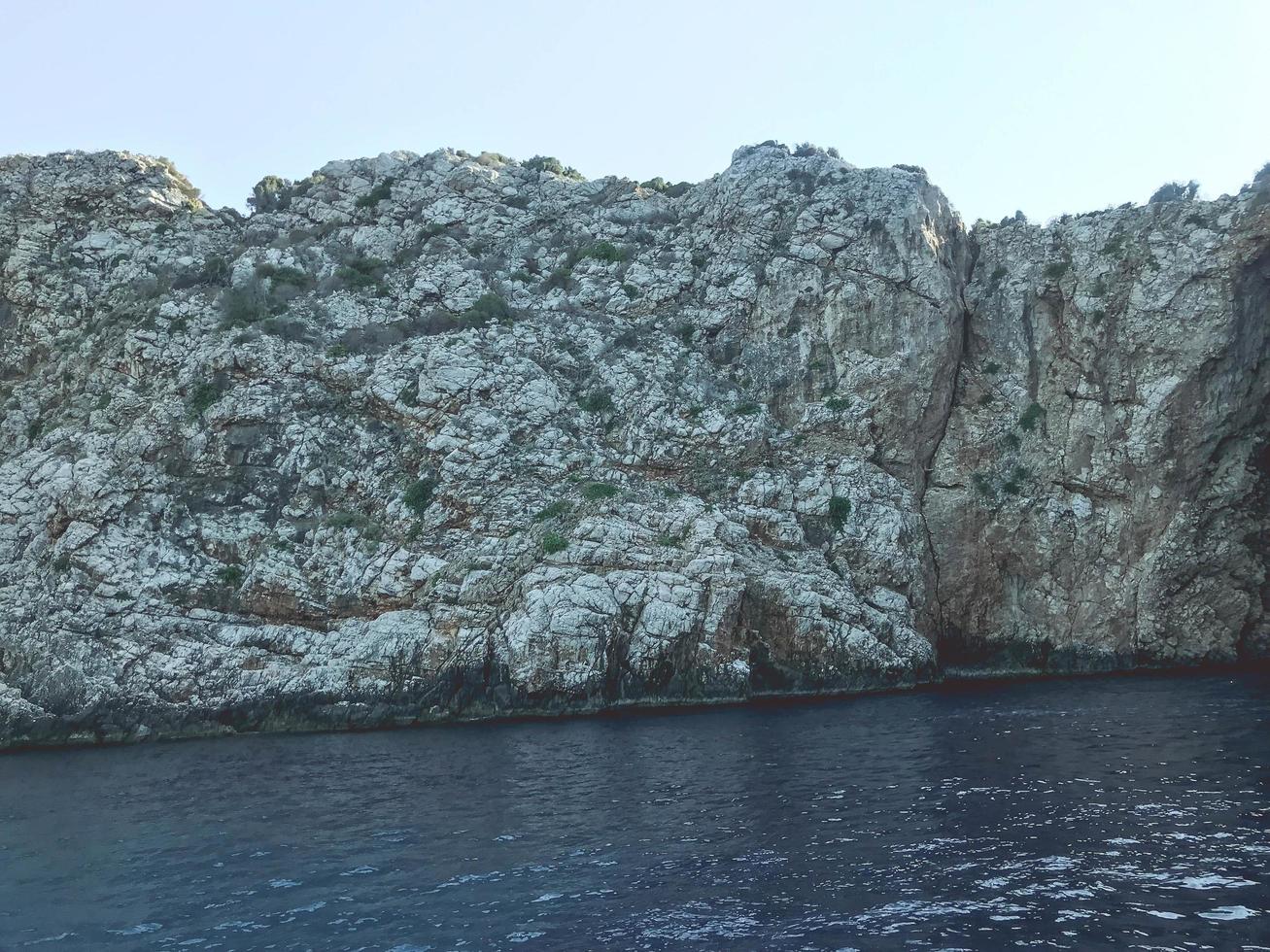 disse per il mare. blu distesa di acqua. un' montagna di sabbia, pietre, un' gola nel il vasto mare. mare ricorrere, viaggio attraverso il bellezze di natura foto