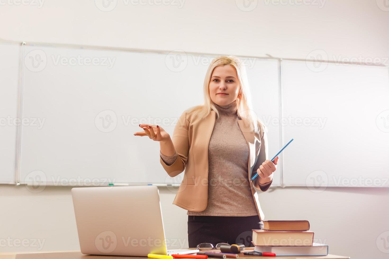 ritratto di bella insegnante Tenere taccuini nel un' aula nel scuola foto