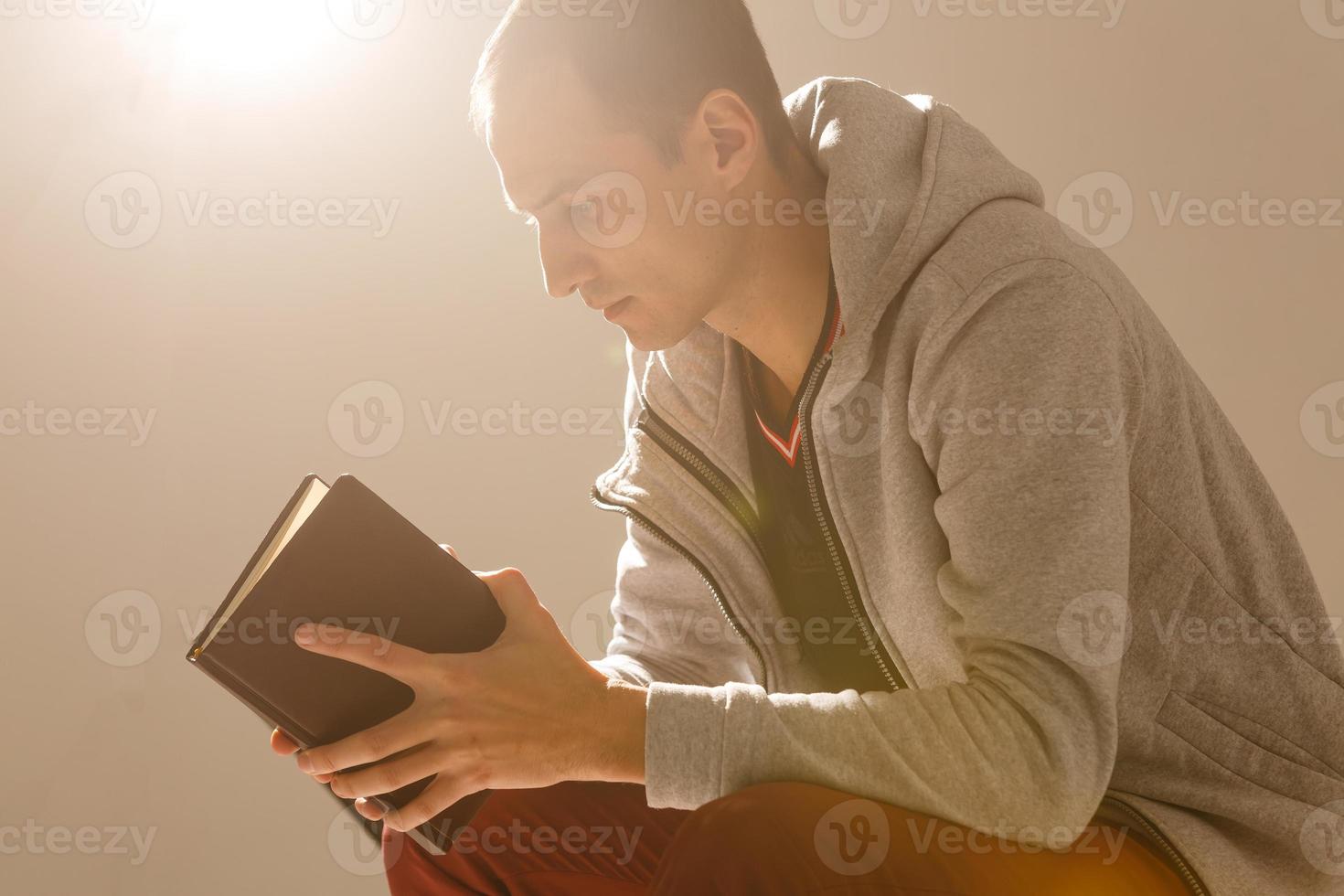 un' uomo preghiere Tenere un' santo Bibbia. foto