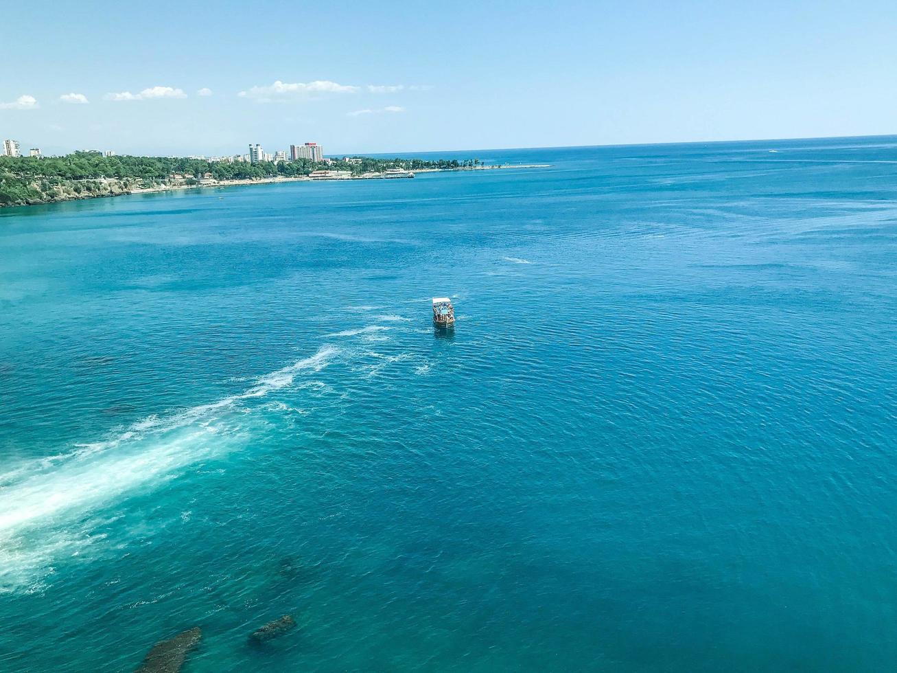 un' yacht con turisti galleggia su il mare con bianca schiuma. yacht con persone su il alto mari. viaggio nel un' tropicale nazione. mare ricorrere foto