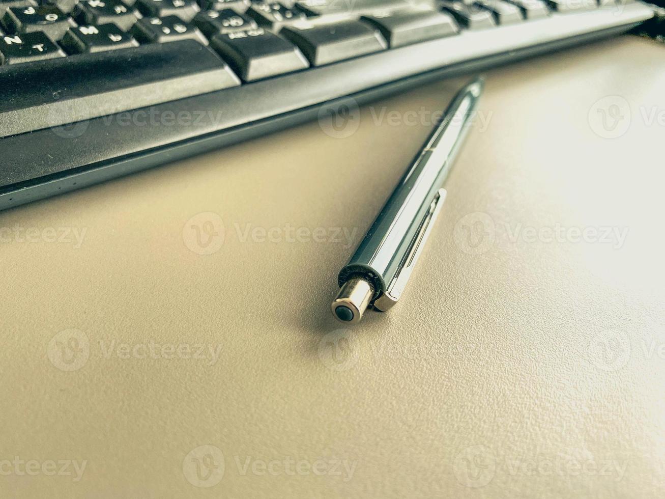 Stazionario su il tavolo nel il ufficio. blu, piccolo penna con un' asta per fabbricazione Appunti su carta. metallo penna per scrivere. Il prossimo per il tastiera per digitando foto
