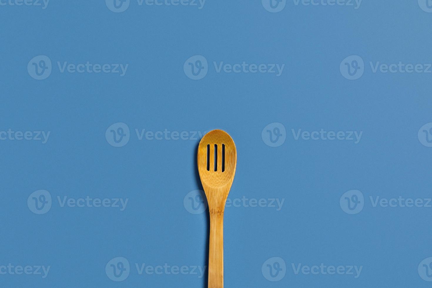 uno di legno cucchiaio su un' blu sfondo. foto