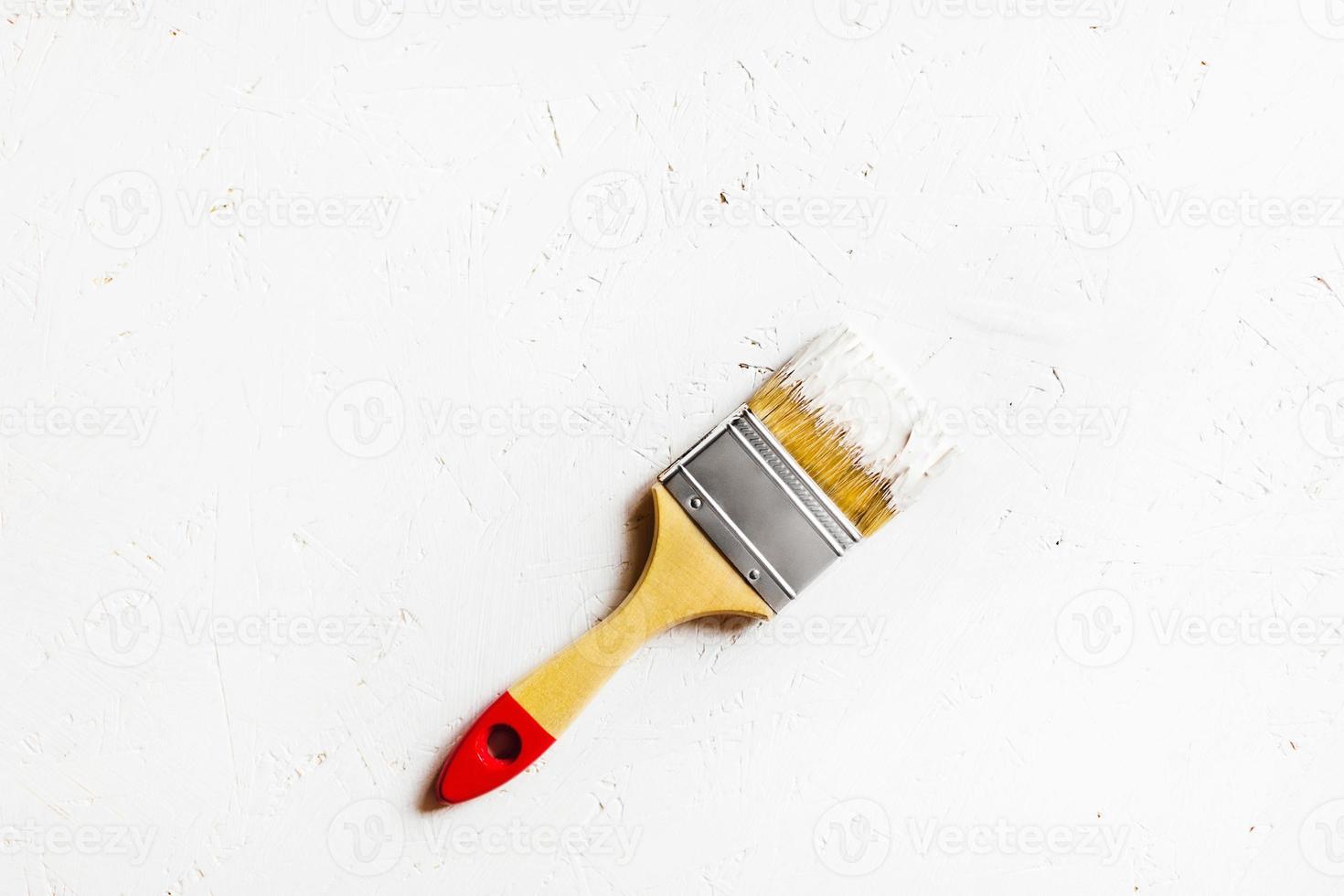 costruzione spazzola con rosso maniglia su dipinto bianca compensato. foto