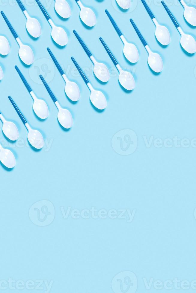 immagine di bianca plastica cucchiai su blu sfondo. foto