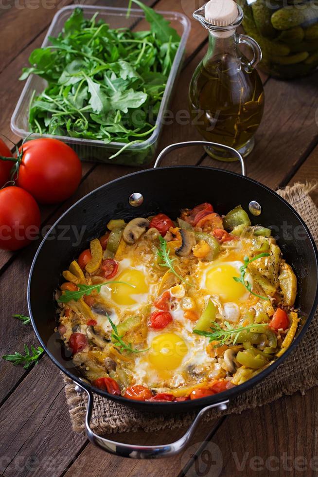 fritte uova con verdure nel un' frittura padella su un' di legno sfondo foto