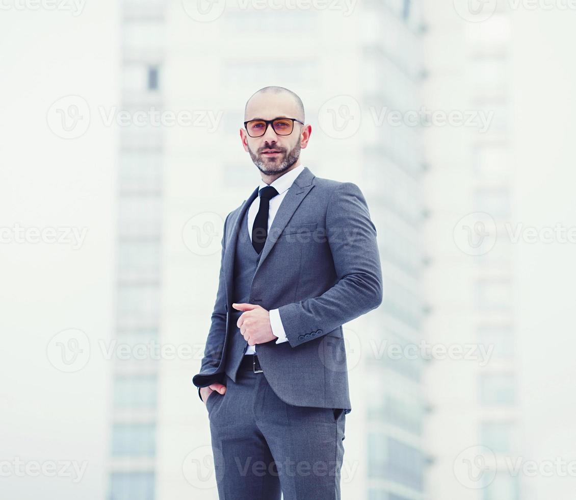 fiducioso giovane uomo nel pieno grigio completo da uomo foto