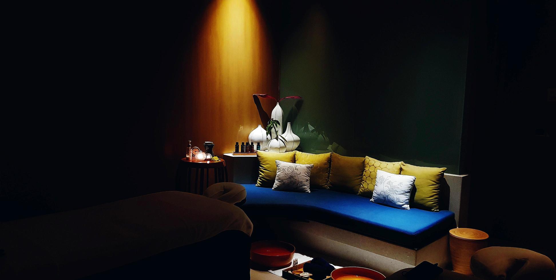 blu divano con bianca e giallo cuscino con parete sfondo. bellissimo posto a sedere e moderno design con fiore vaso e luce. confortevole mobilia concetto. foto