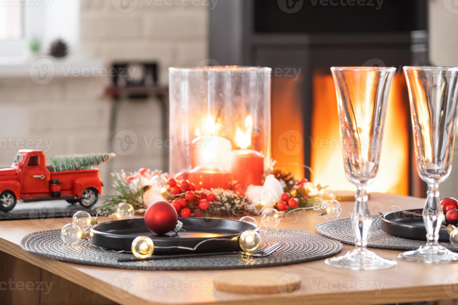 festivo interno di Casa è decorato per Natale e nuovo anno nel soffitta stile con nero fornello, il camino, Natale albero. caldo studio camera con impostato tavolo, ardente Di legno, accogliente e riscaldamento di casa foto