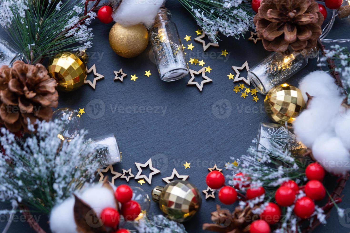 festivo telaio con un' posto per Natale e nuovo anni tema testo. paillettes, stelle, ghirlanda, coni, palle su un' nero pietra sfondo di ardesia. copyspace, saluto carta foto