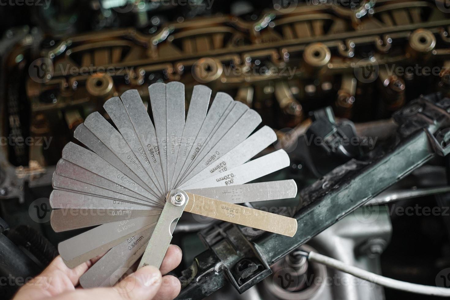 auto meccanico utilizzando tastatore valutare impostato il auto valvola. misurazione valvola autorizzazione con punteria tastatore valutare impostato foto