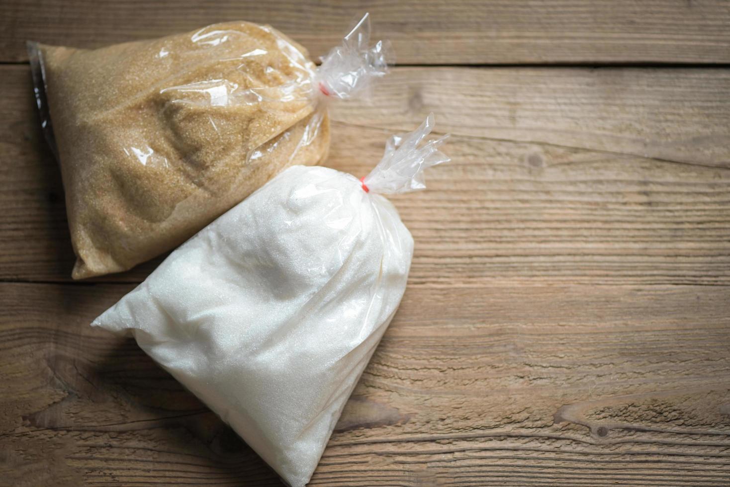 zucchero Borsa su di legno sfondo, bianca e Marrone zucchero per cibo e dolci dolce caramella mucchio di dolce zucchero cristallino granulato foto