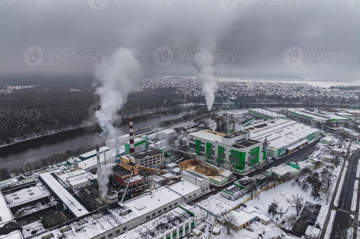 inverno panoramico aereo Visualizza di il Fumo di tubi di un' chimico pianta o la lavorazione del legno impresa. aria e acqua inquinamento concetto. foto