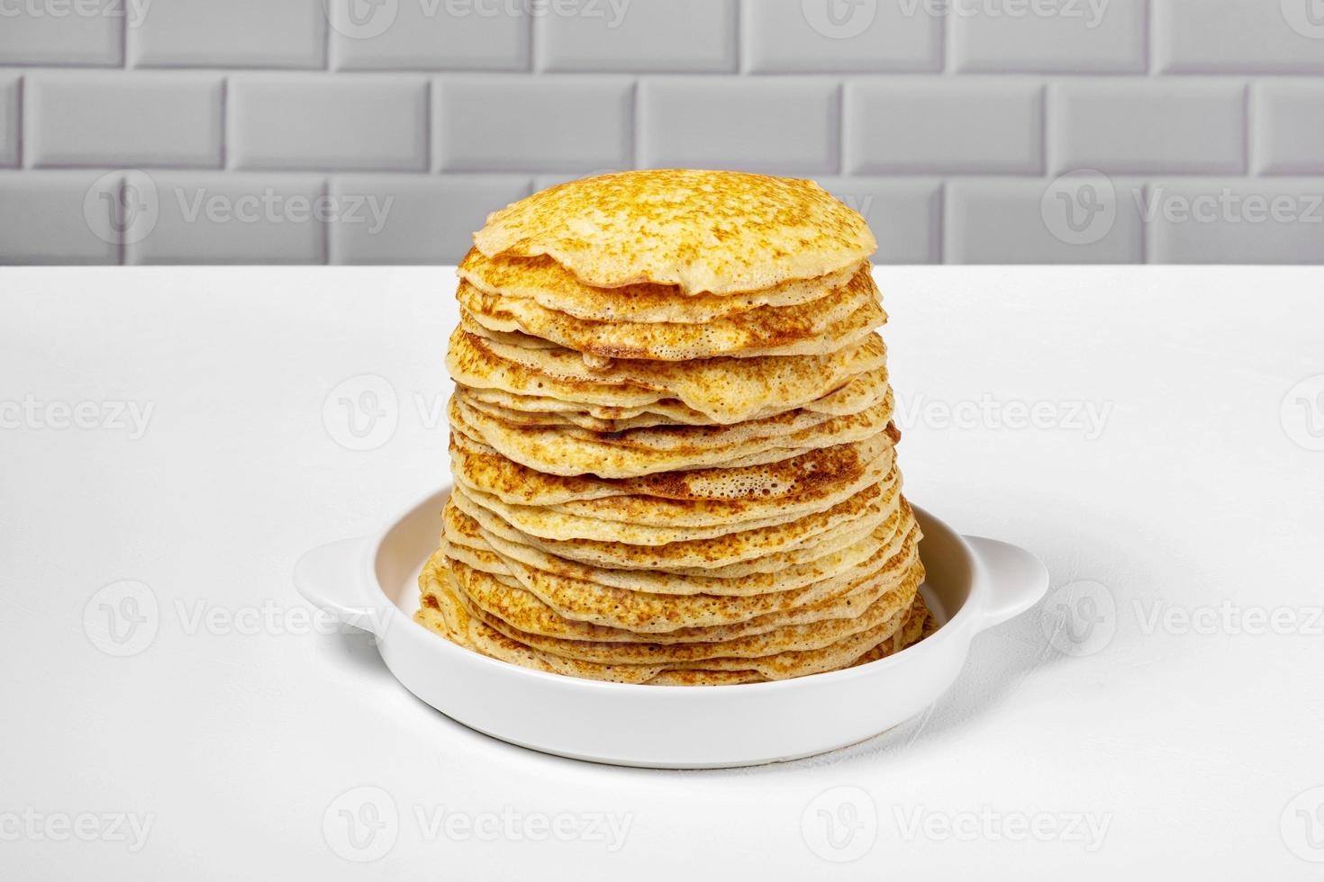 pila di appena al forno Pancakes menzogna nel bianca ceramica modulo. foto