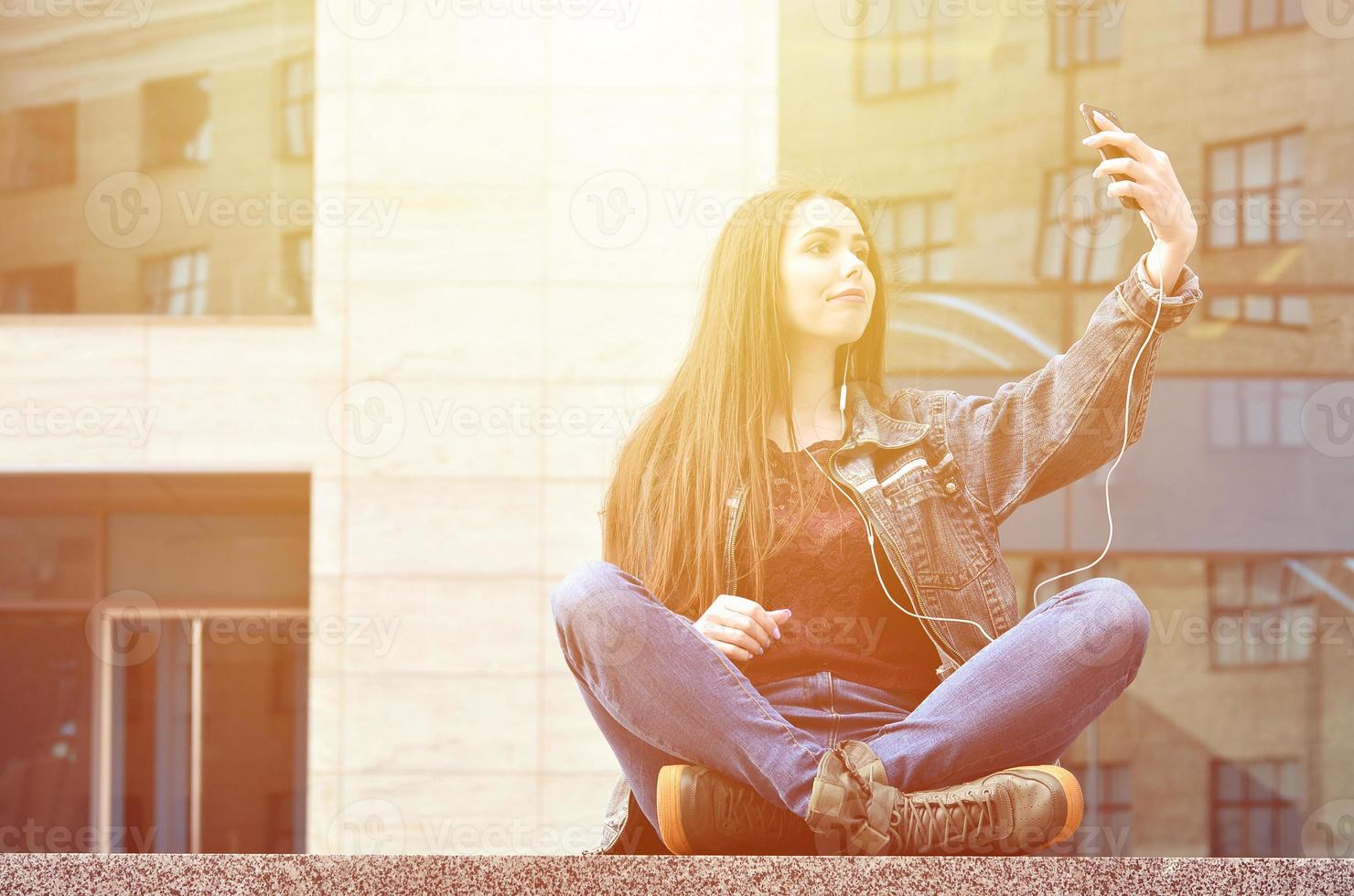 giovane ragazza fare autoscatto su il sfondo di un ufficio edificio foto