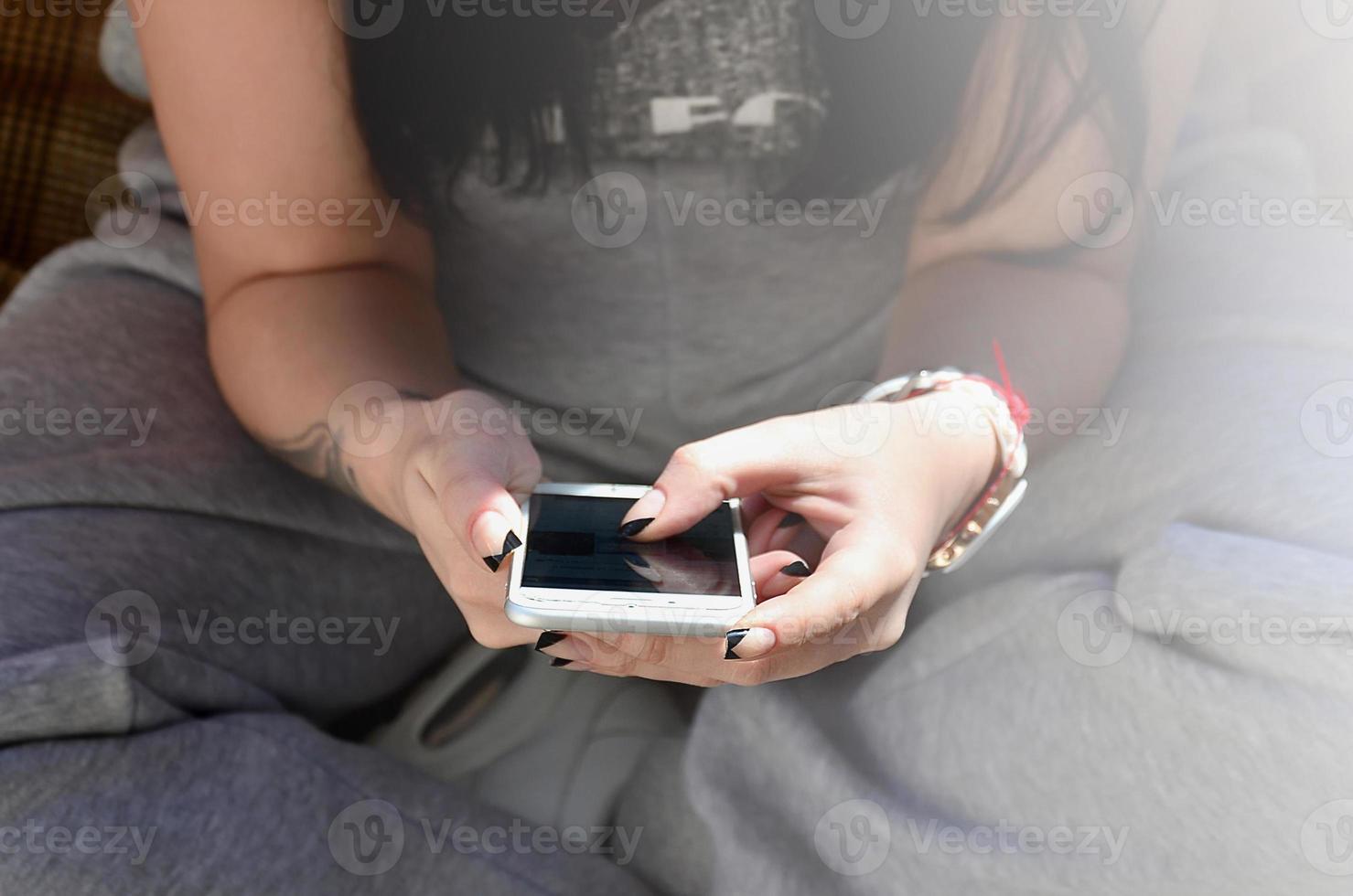 il brunetta ragazza usi un' moderno toccare smartphone foto