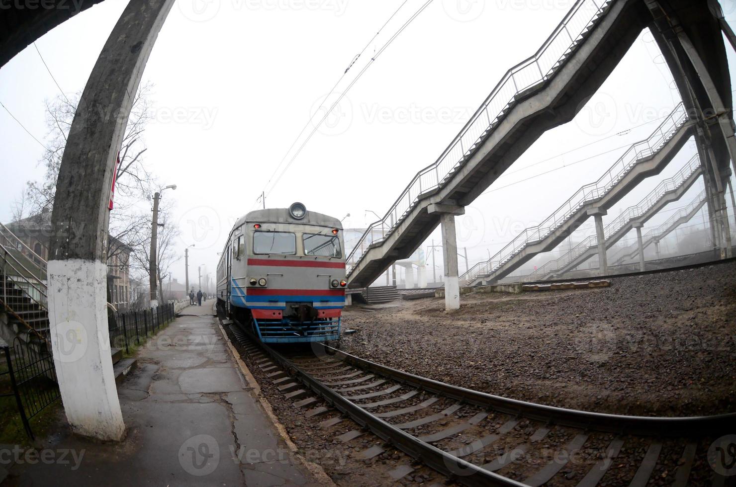 il ferrovia traccia nel un' nebbioso mattina. il ucraino suburbano treno è a il passeggeri stazione. fisheye foto con è aumentato distorsione