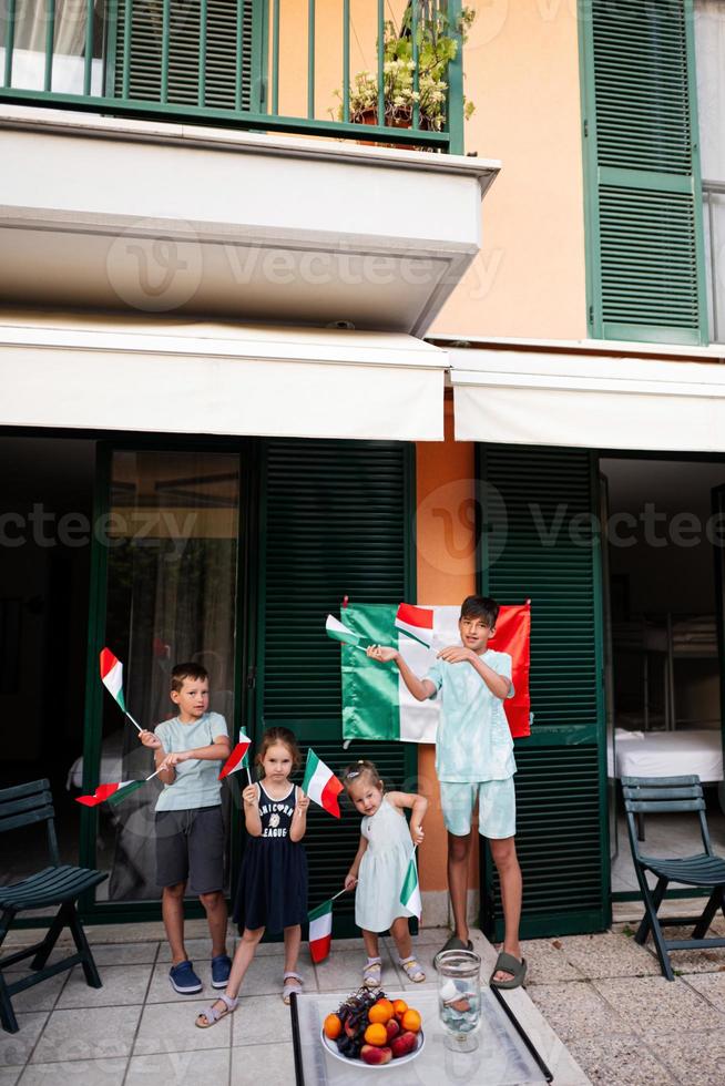 contento quattro bambini con italiano bandiere festeggiare repubblica giorno di Italia. foto