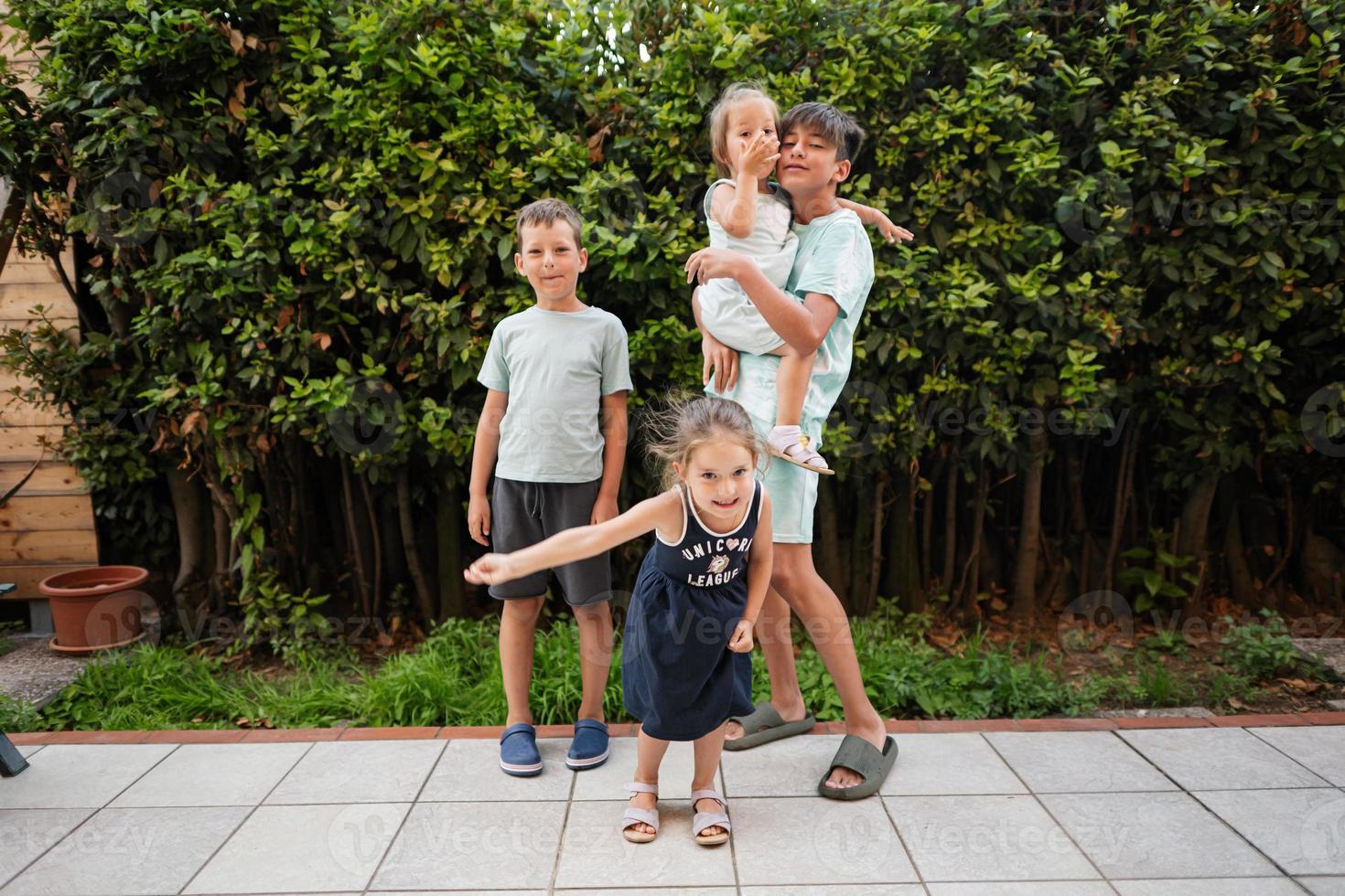 quattro contento bambini su il terrazza di il Casa. fratelli e sorelle. foto
