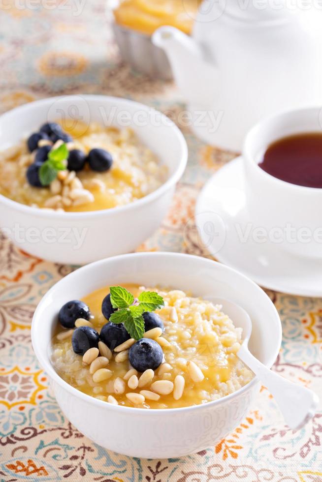 cucinato miglio porridge con Limone cagliata e mirtillo foto