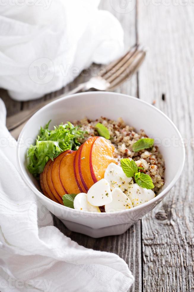 ciotola di quinoa con pesca e mozarella foto