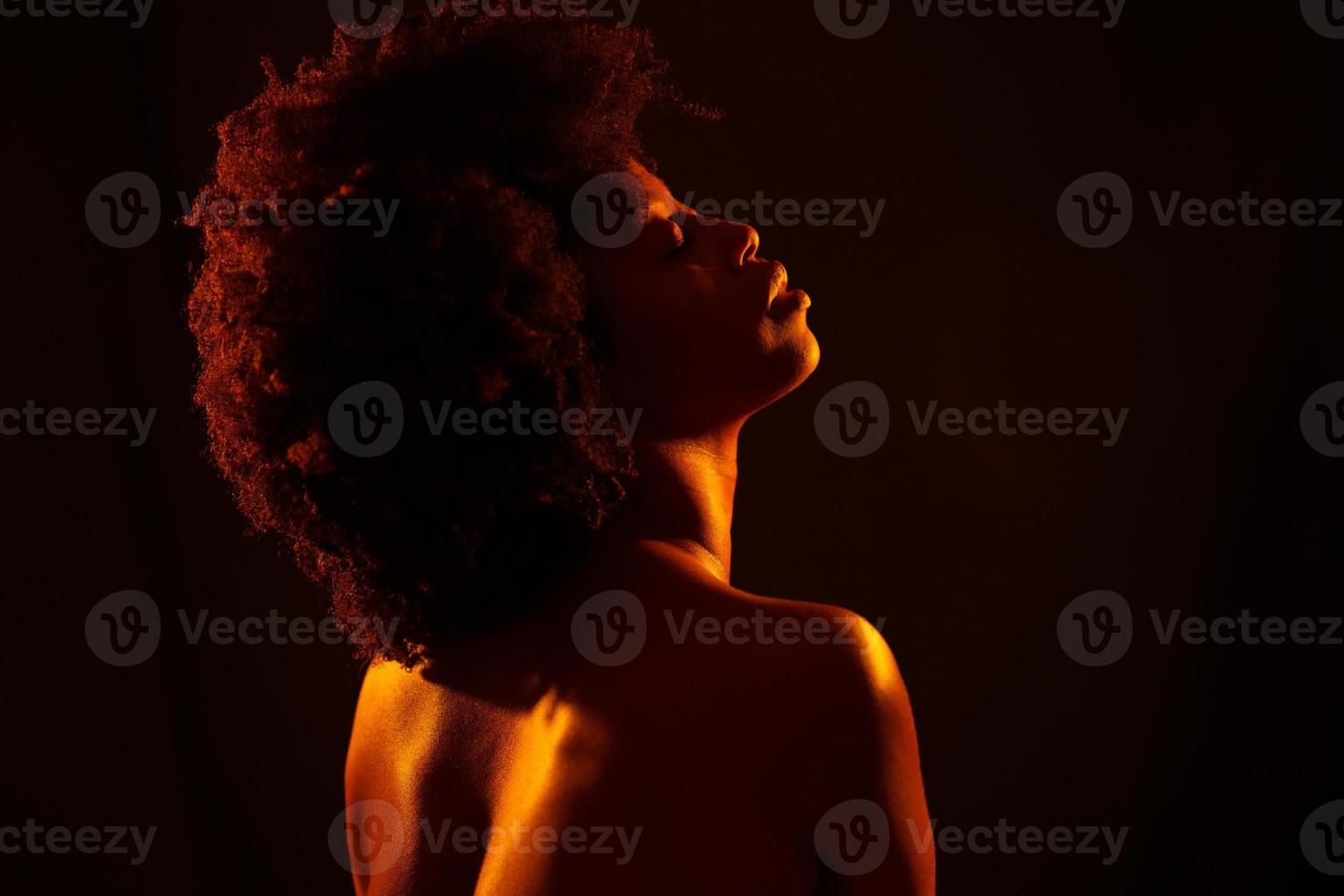 nudo africano americano femmina sotto arancia leggero foto