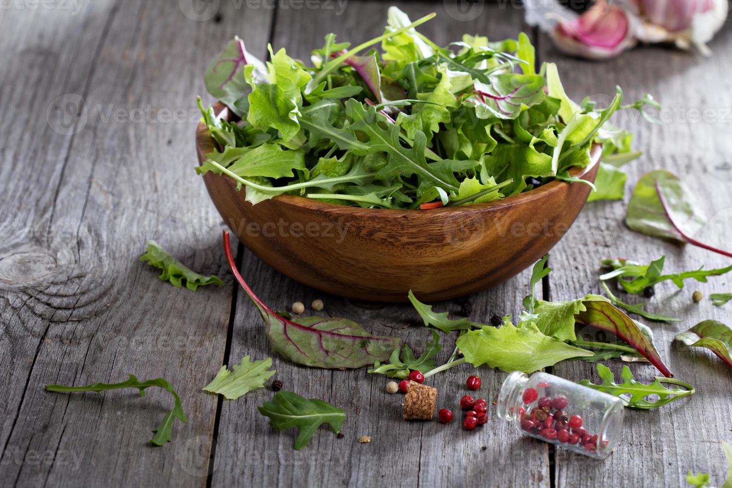 foglie di insalata verde in una ciotola di legno foto