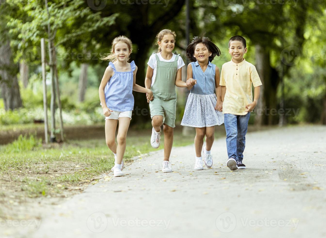 gruppo di asiatico e caucasico bambini avendo divertimento nel il parco foto