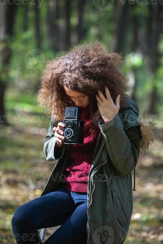 adolescente ragazza con retrò telecamera assunzione fotografie nel natura