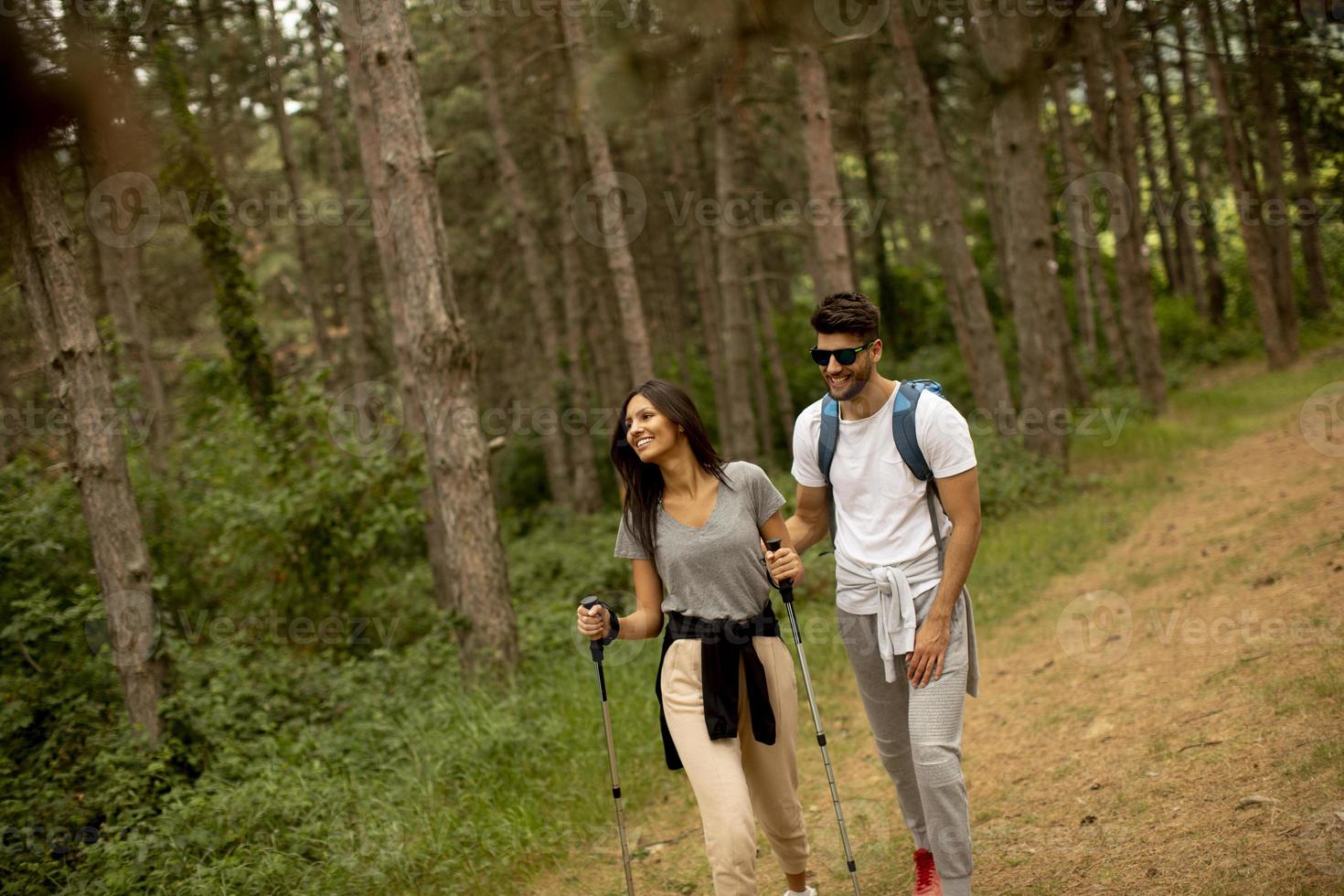 coppia di escursionisti con zaini camminare attraverso il foresta foto