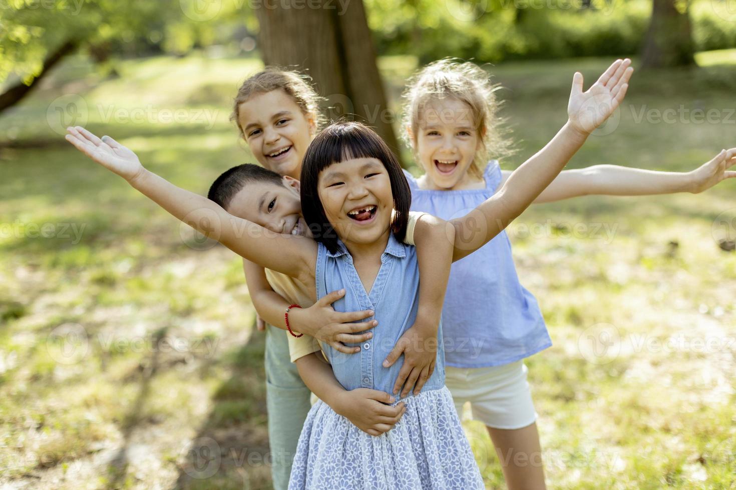 gruppo di asiatico e caucasico bambini avendo divertimento nel il parco foto